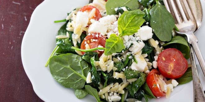 a plate of spinach with crumbled feta